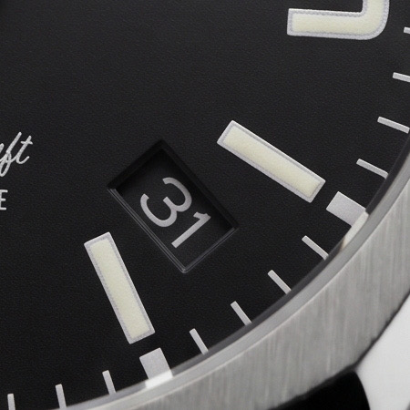 Macro du guichet de date et des index luminescents.